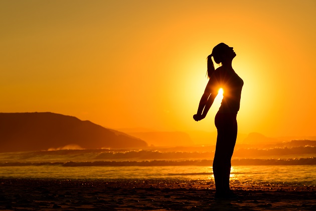 Relaxing Exercises On Beach At Sunset
